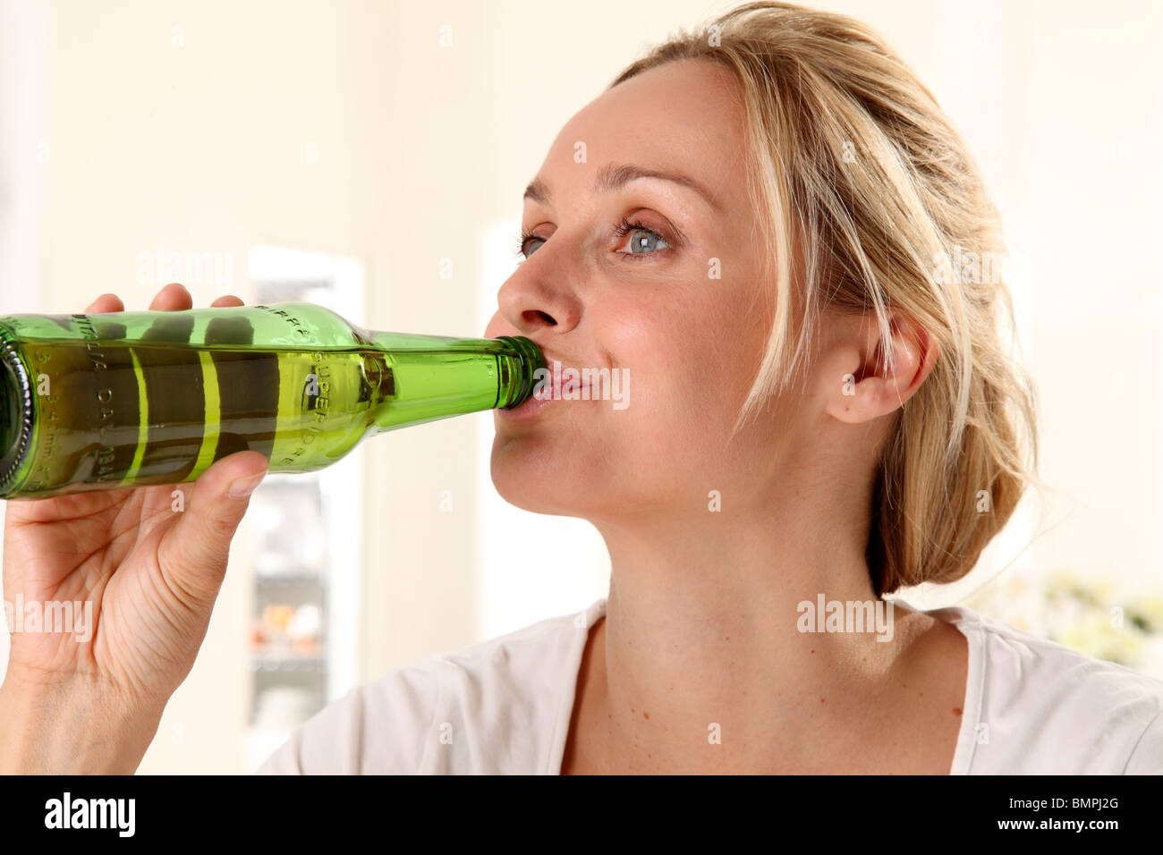 WOMAN DRINKING BEER FROM BOTTLE Stock Photo