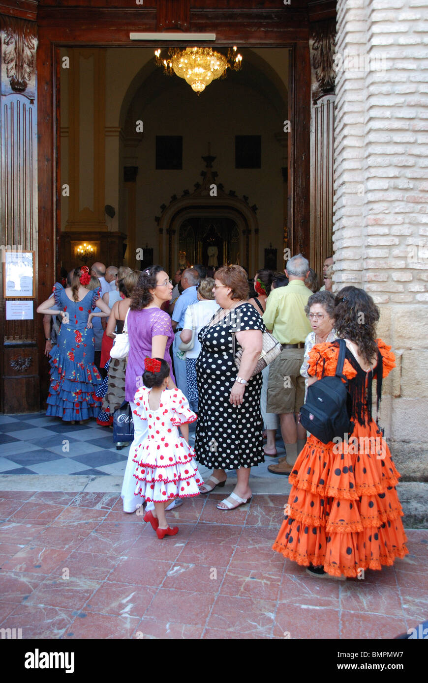 Women in traditional dress entering the church, Marbella, Costa del Sol, Malaga Province, Andalucia, Spain, Western Europe. Stock Photo