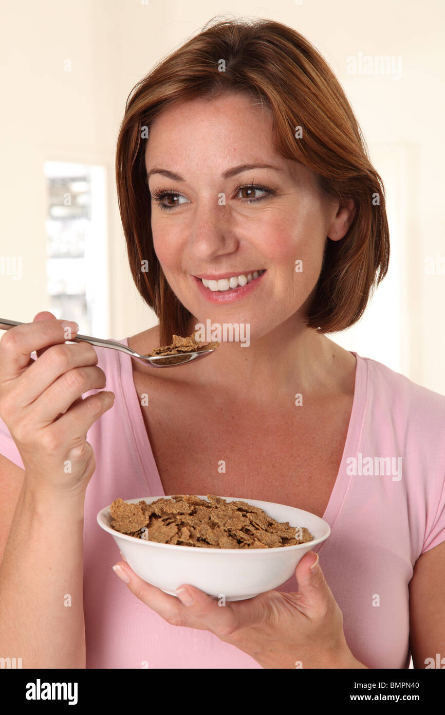 WOMAN EATING BRAN FLAKES BREAKFAST CEREAL Stock Photo