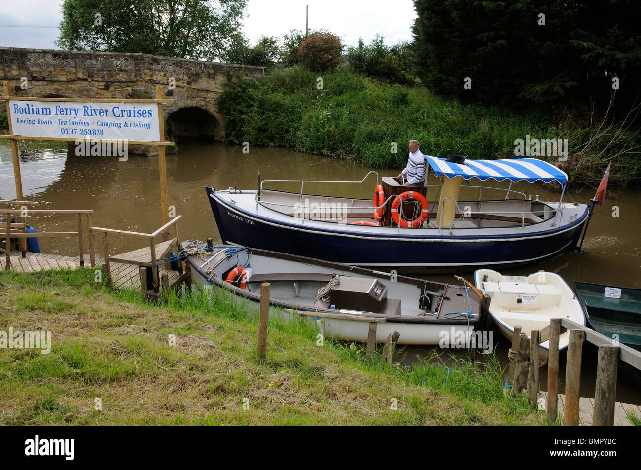 Hire boats alongside on the River Rother & the Bodiam passenger ferry at Newenden Cranbrook Kent England UK Stock Photo