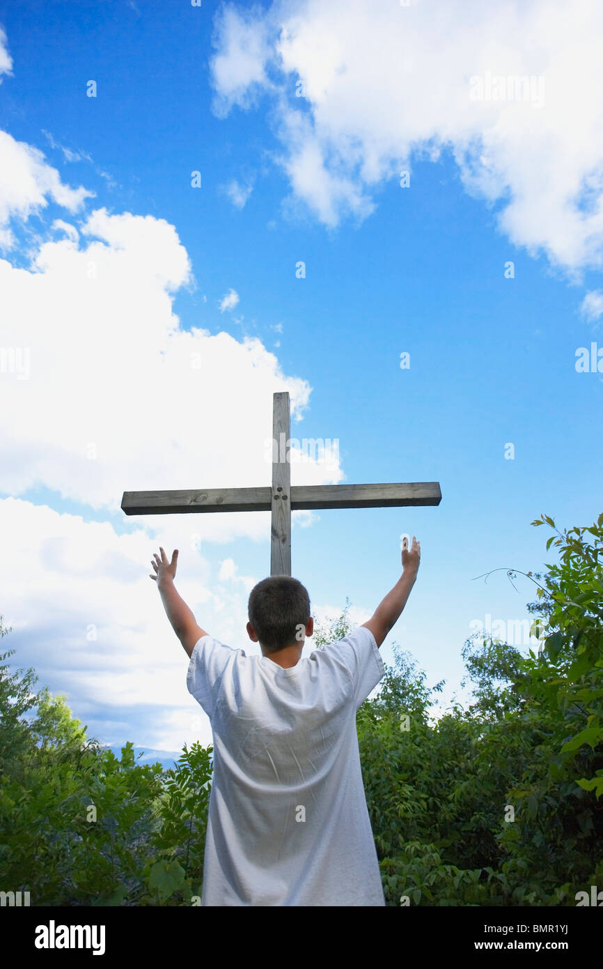 A Teenage Boy With Arms Raised Towards The Cross Stock Photo Alamy