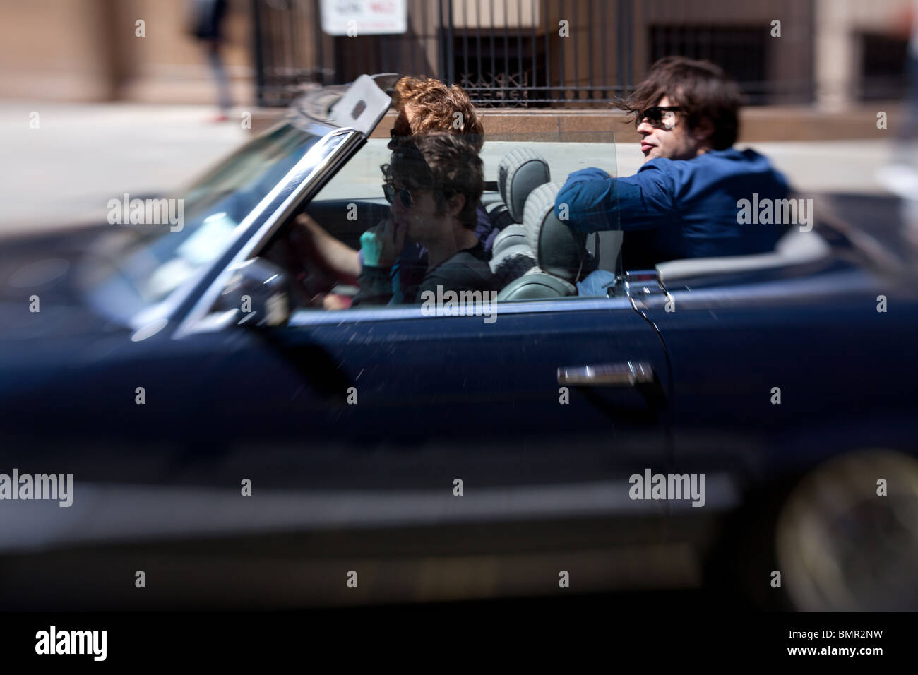 Cool guys in a convertible car driving through Covent Garden in London, England. Stock Photo
