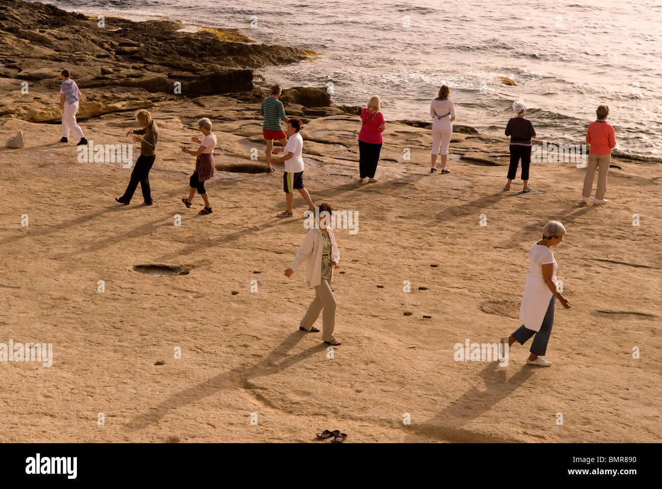 People doing early morning Tai Chi on the Sliema seafront, Malta. Stock Photo