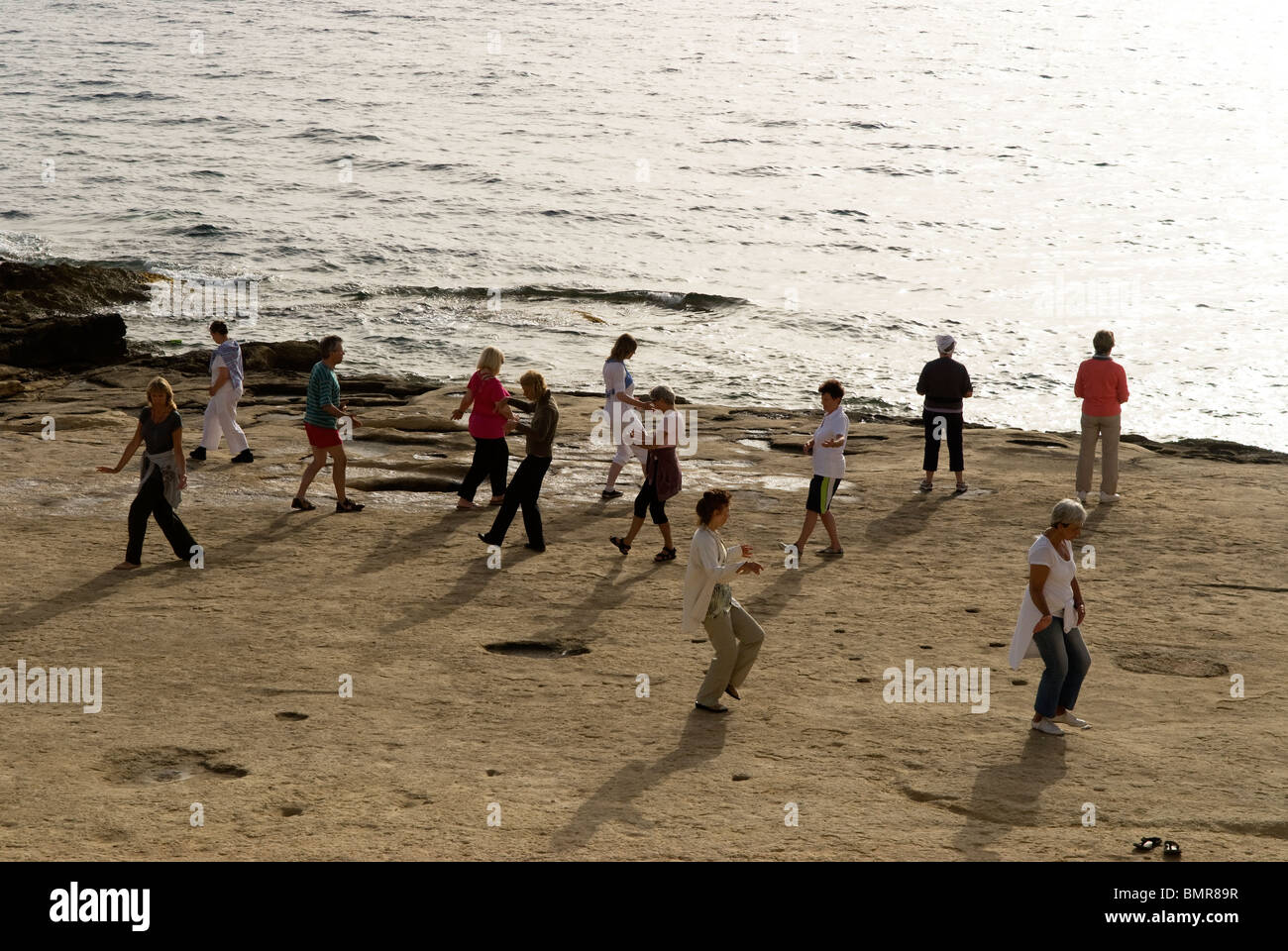 People doing early morning Tai Chi on the Sliema seafront, Malta. Stock Photo