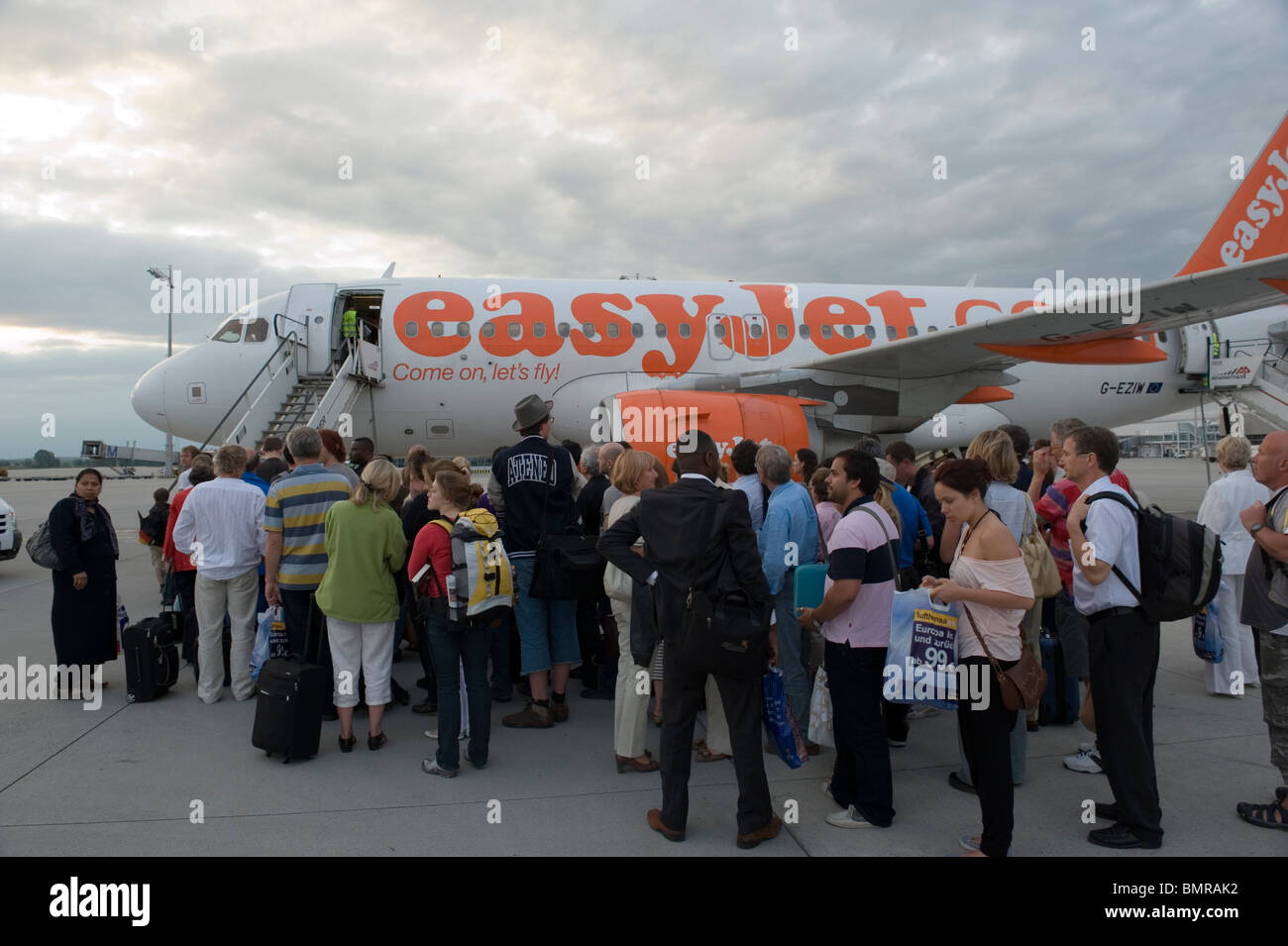 Airline passengers boarding a plane of discount airline Easyjet at Munich airport Germany Stock Photo