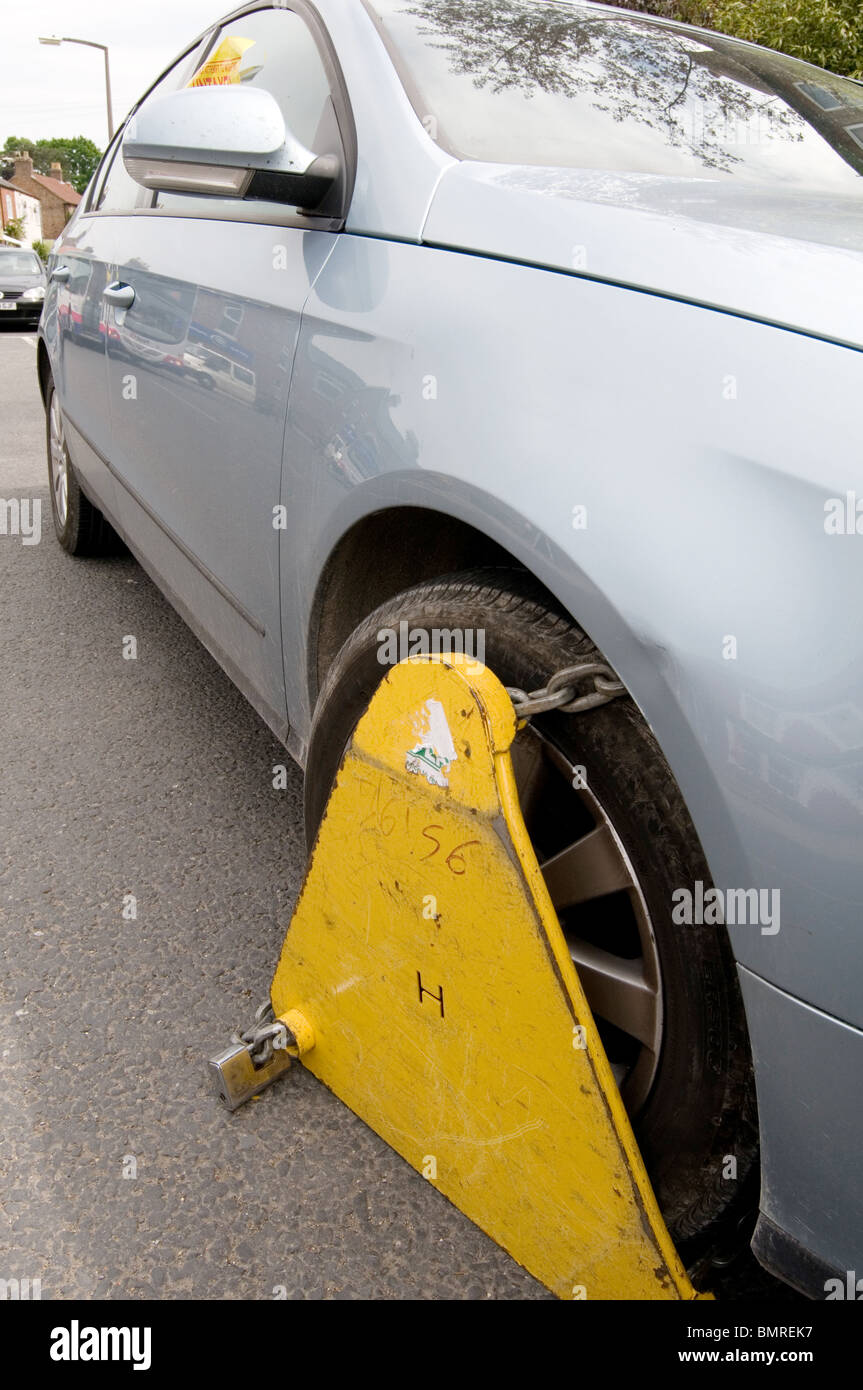 untaxed car tax road avoidance taxation enforcement clamp clamped cars  clamping clamper clampers clamps immobilized vehicle Stock Photo - Alamy