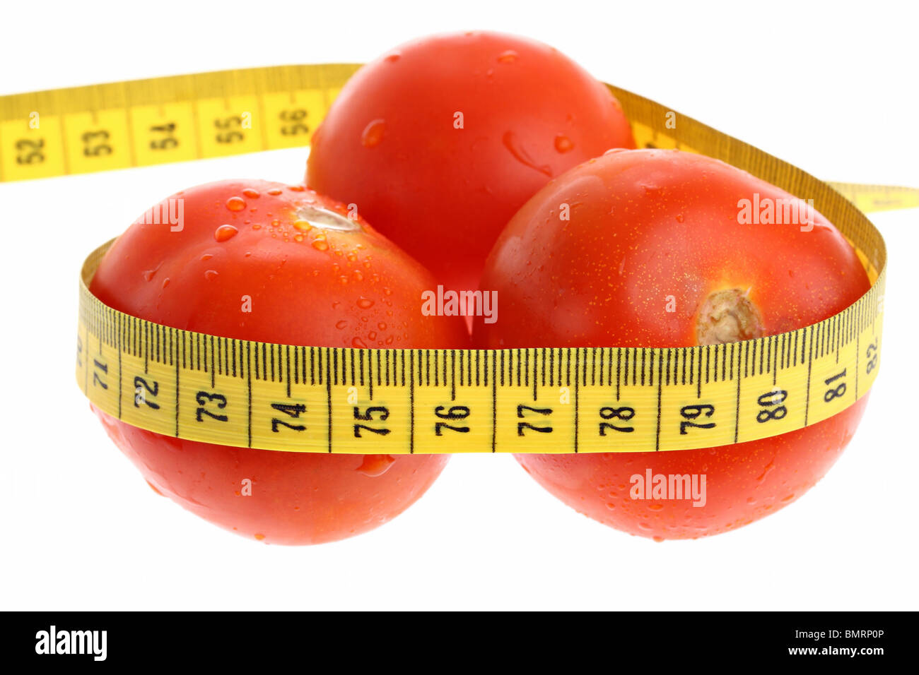 Tomatoes with yellow measuring tape as losing weight concept isolated on white Stock Photo