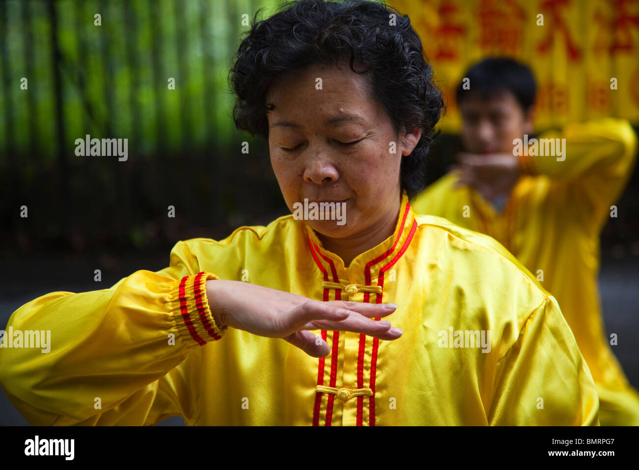 woman practising Falun Gong, a form of Chinese meditation exercises in a position known as 'reinforcing Supernatural Powers'. Stock Photo