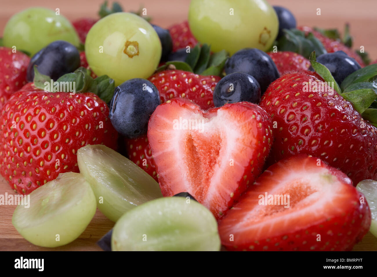 freshly cut washed clean ripe strawberries blueberries and grapes