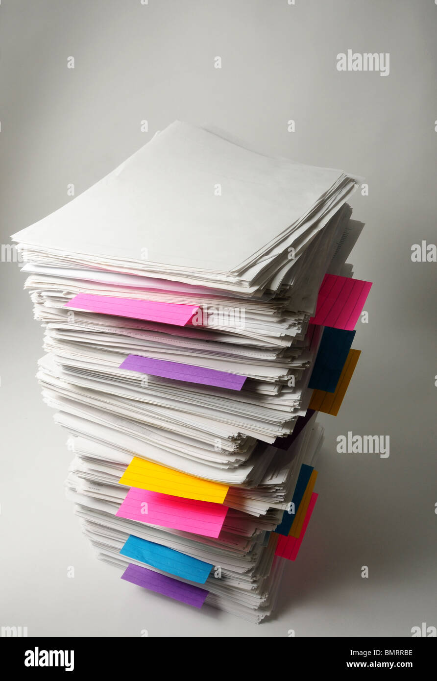 A stack of used sheets of white paper with colored paper markers. Stock Photo