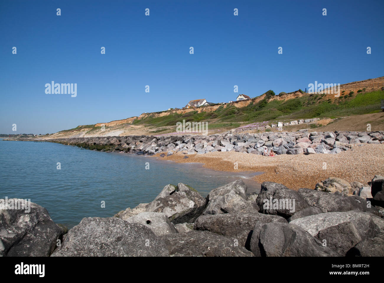 cliff top houses and Rock stone groynes sea defences at Barton on Sea Stock Photo