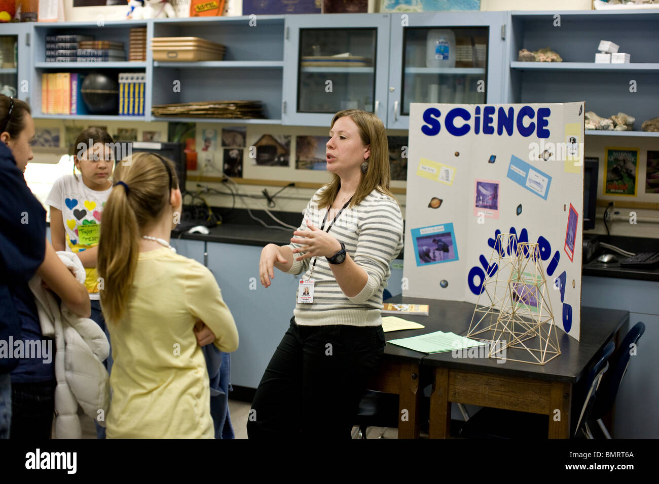 Female science teacher talks to middle school students about the