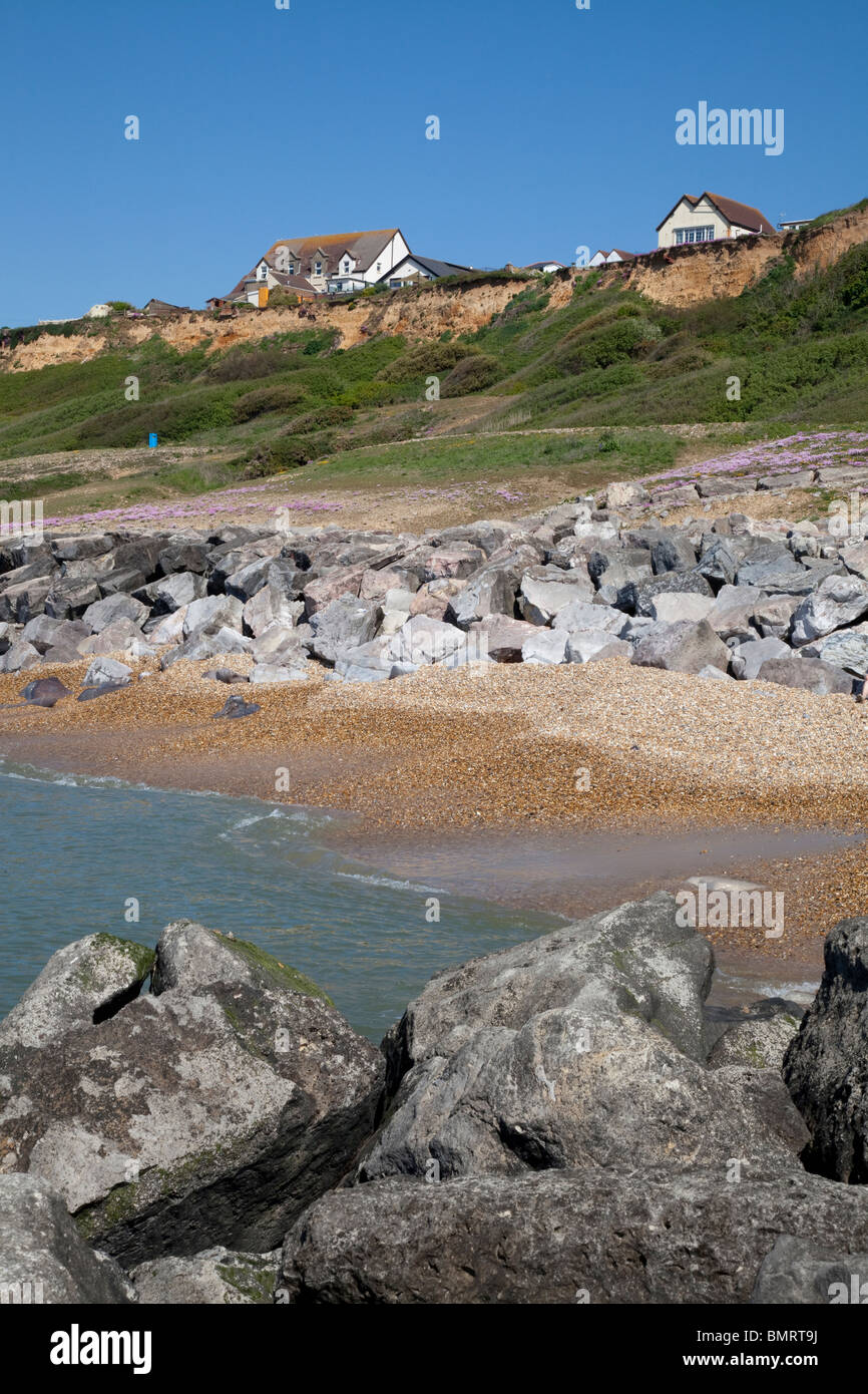cliff top houses and Rock stone groynes sea defences at Barton on Sea Stock Photo