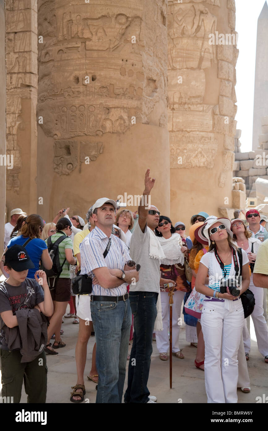 Tour guide Egypt; Tourists on a guided tour in the Hypostyle Hall,  the Temple of Karnak, Luxor, Egypt Stock Photo