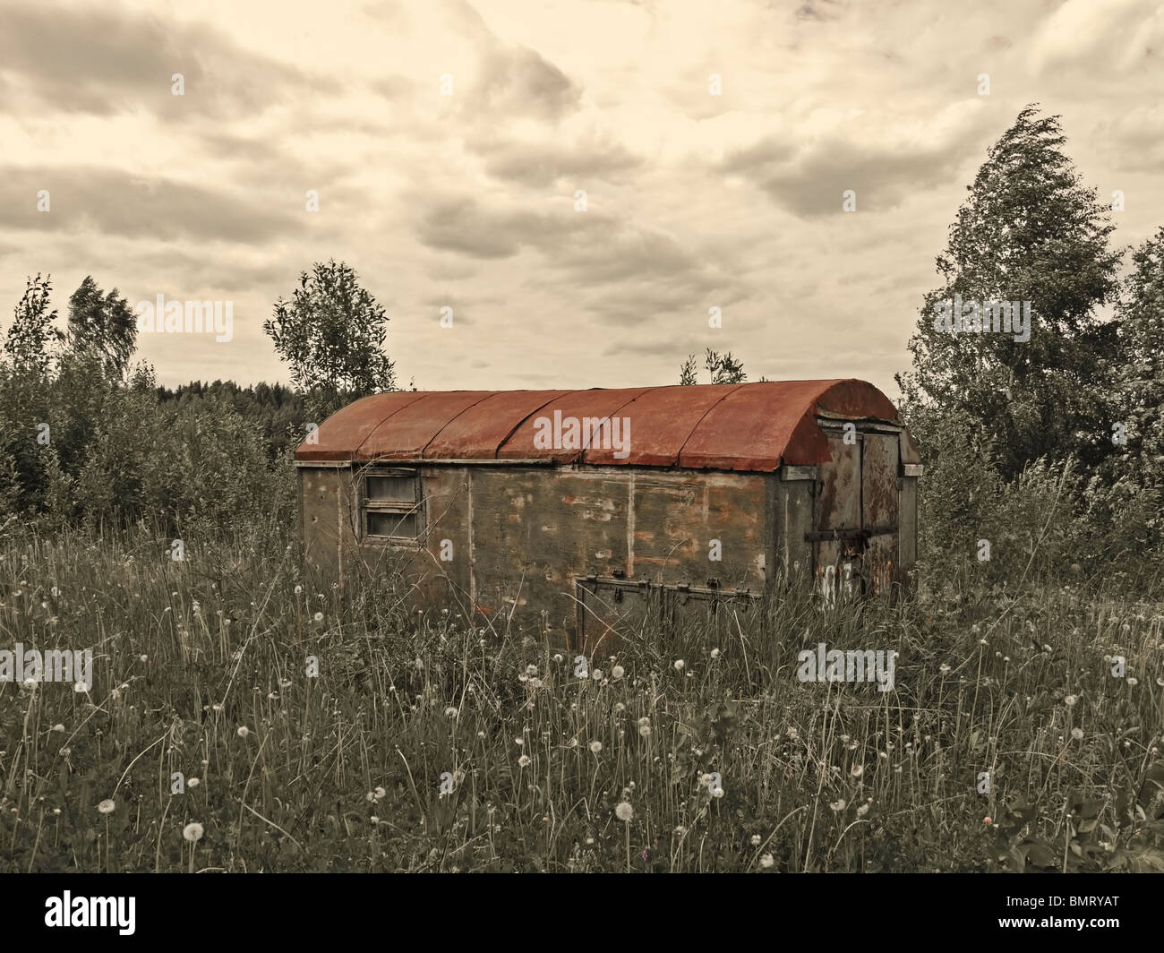 Old living house made from railway wagon in wastelands in Izhevsk region, Udmurt Republic, Russia - in sepia and red colors Stock Photo