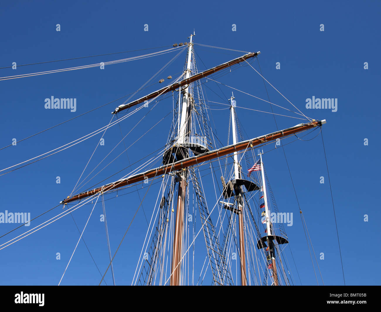 tall ship three masted masts ratings ladders flags blue sky sails Stock ...