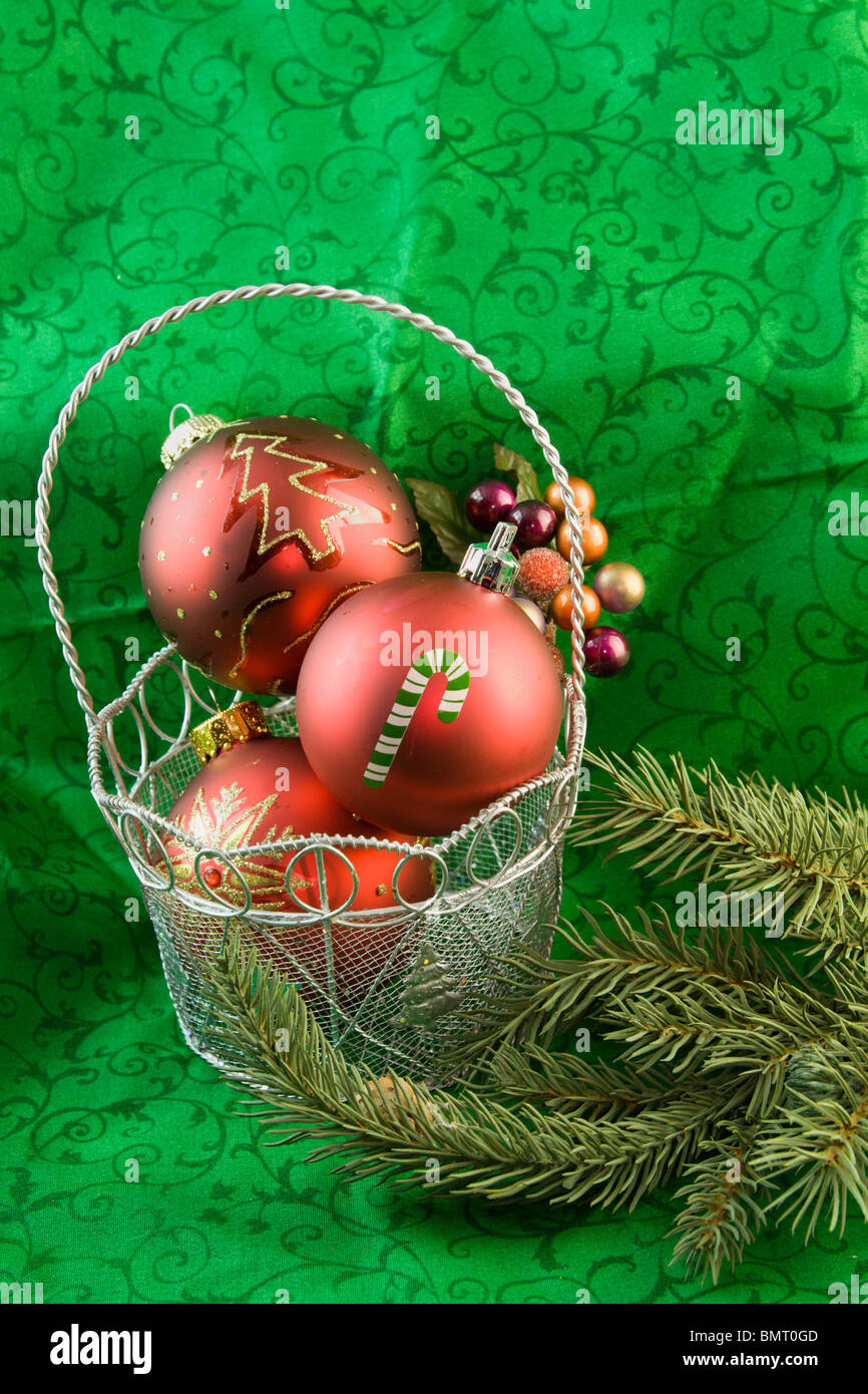 three red, Christmas ornaments in a silver basket Stock Photo
