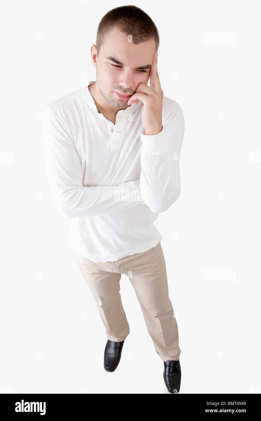 Young man looking away and thinking with head in hands Stock Photo