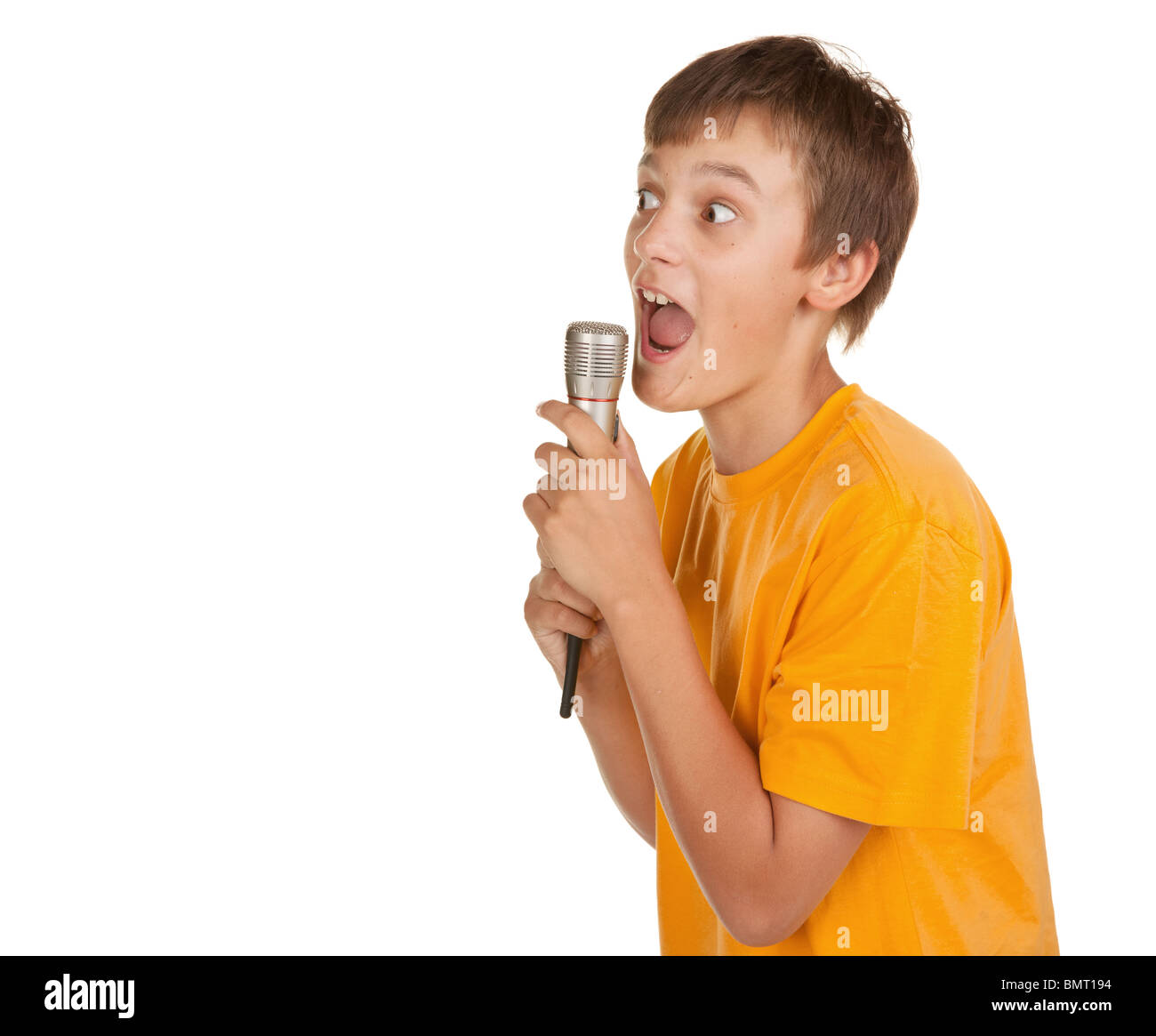 boy singing karaoke or talking on microphone looking at copyspace Stock Photo
