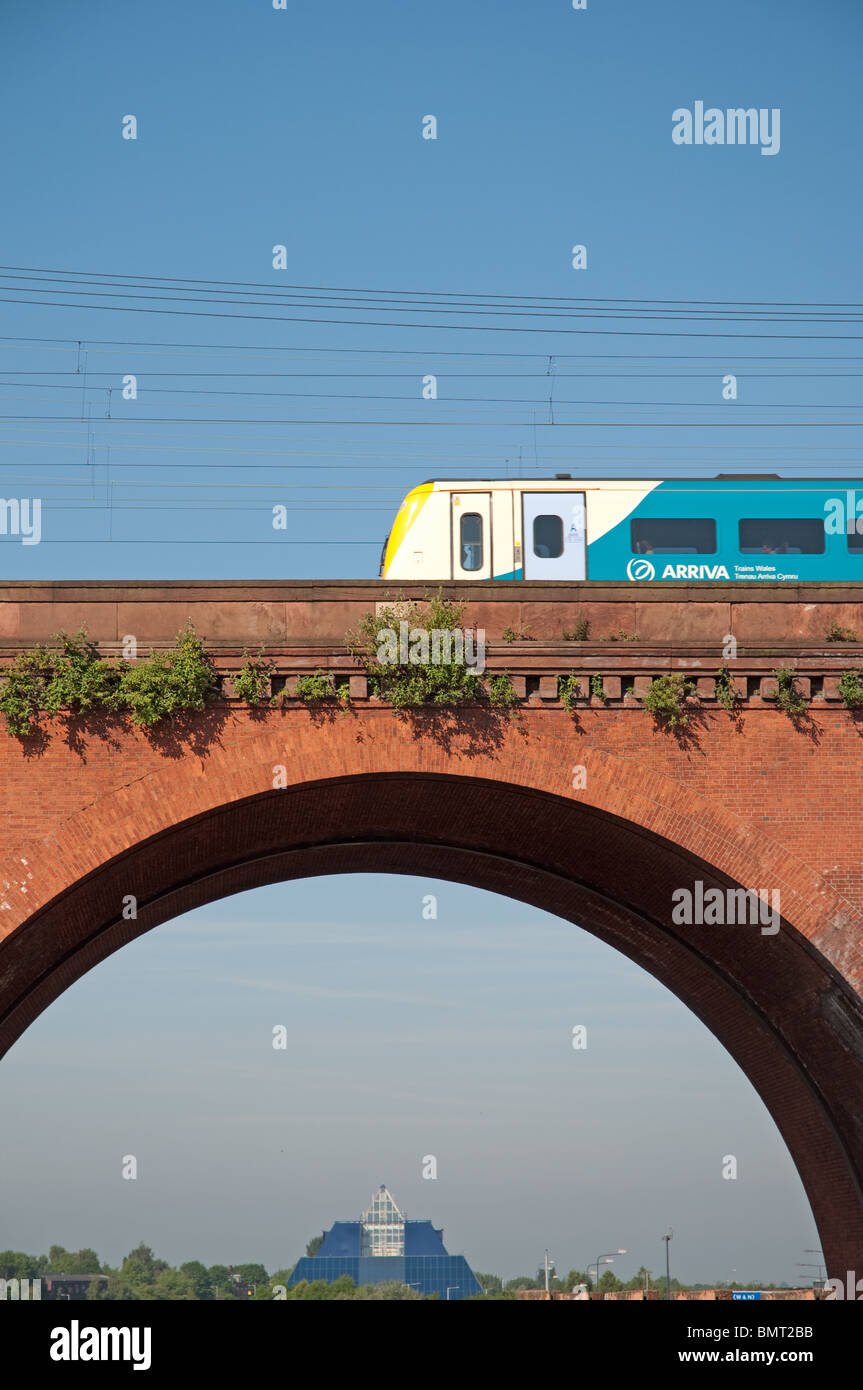 An Arriva train travels across Stockport Viaduct,built with 11 million bricks. Co-op Bank Pyramid building in the background. Stock Photo