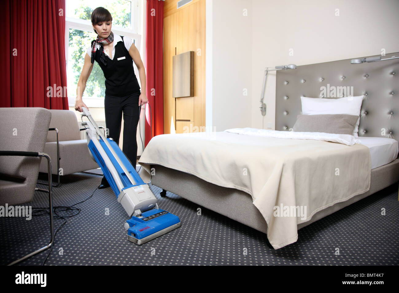 Hotel, room service, house keeping at work in a hotel room. Cleaning up, making the beds Stock