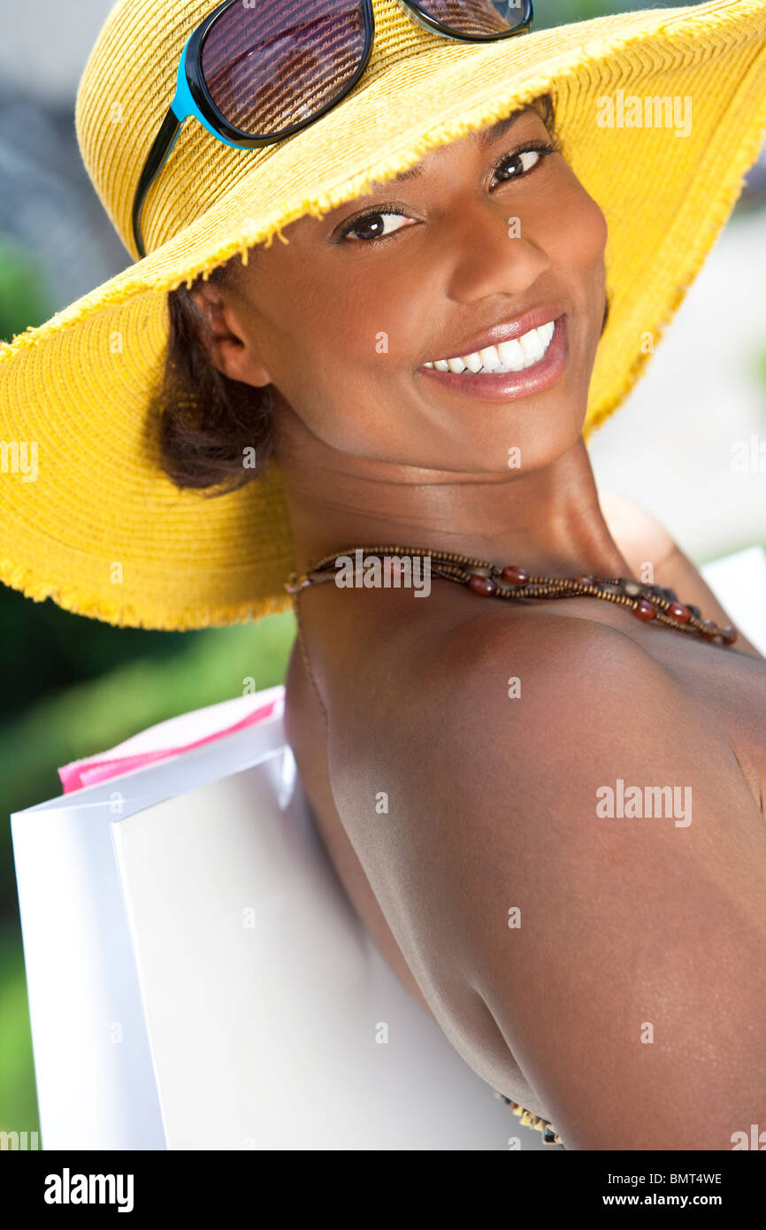 Beautiful and Fashionable African American woman smiling with colorful hat and shopping bags Stock Photo