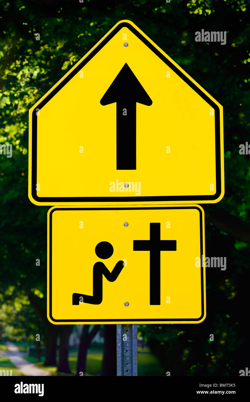 Willmar, Minnesota, United States Of America; A Sign With An Arrow And A Person Kneeling At A Cross Stock Photo