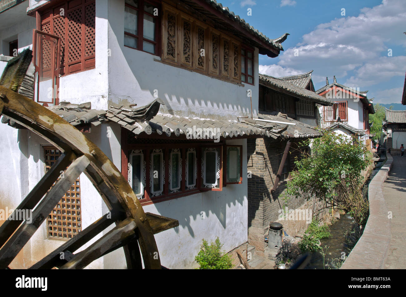 Houses along canal with water wheel Lijiang Old Town Yunnan China Stock Photo