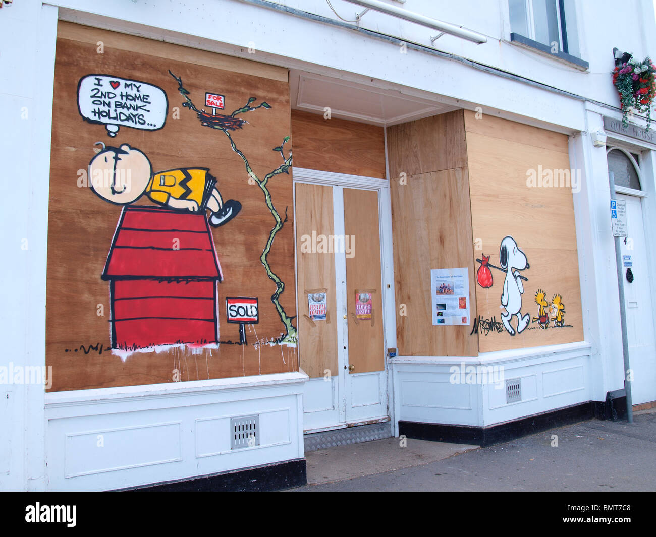 A closed down shop with a graffiti protest against second home owners, Appledore, Devon. Stock Photo