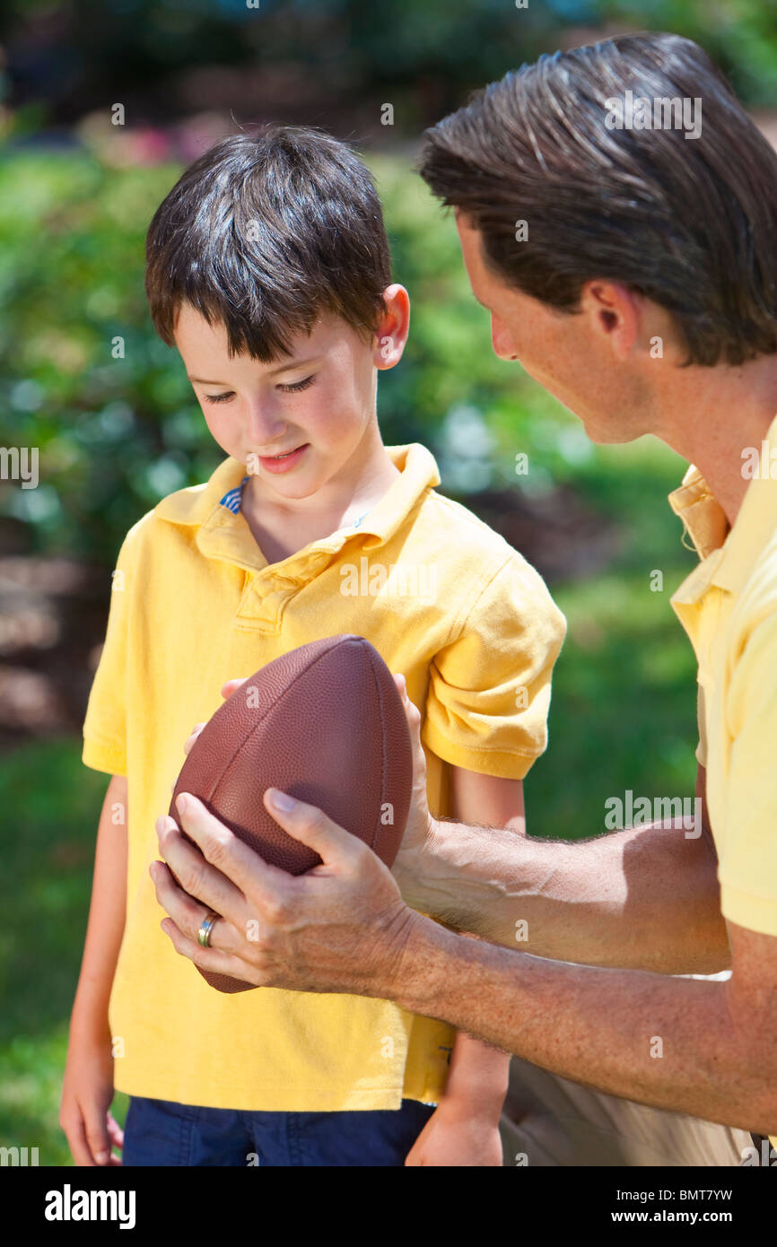 A Father Teaching His Son How To Play American Football Outside In a-father-teaching-his-son-how-to-play-american-football-outside-in