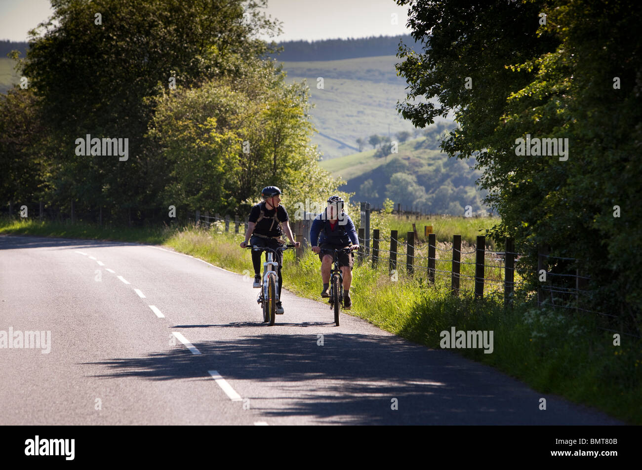 UK, England, Derbyshire, Edale, cyclists in Hope Valley cycling on empty road Stock Photo