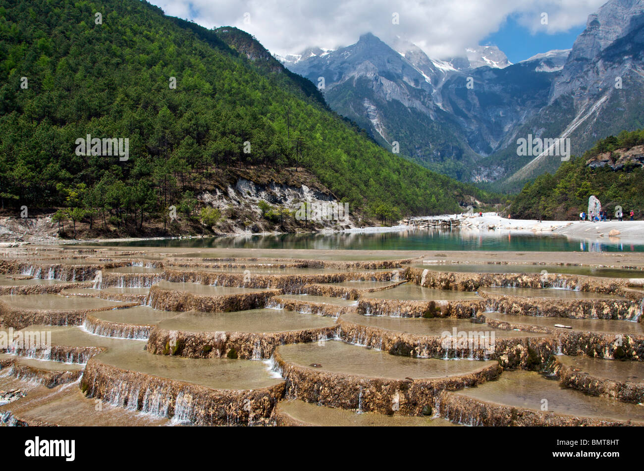 Water running over weir Yulong Xueshan (Jade Dragon) Mountain near Lijiang Yunnan China Stock Photo
