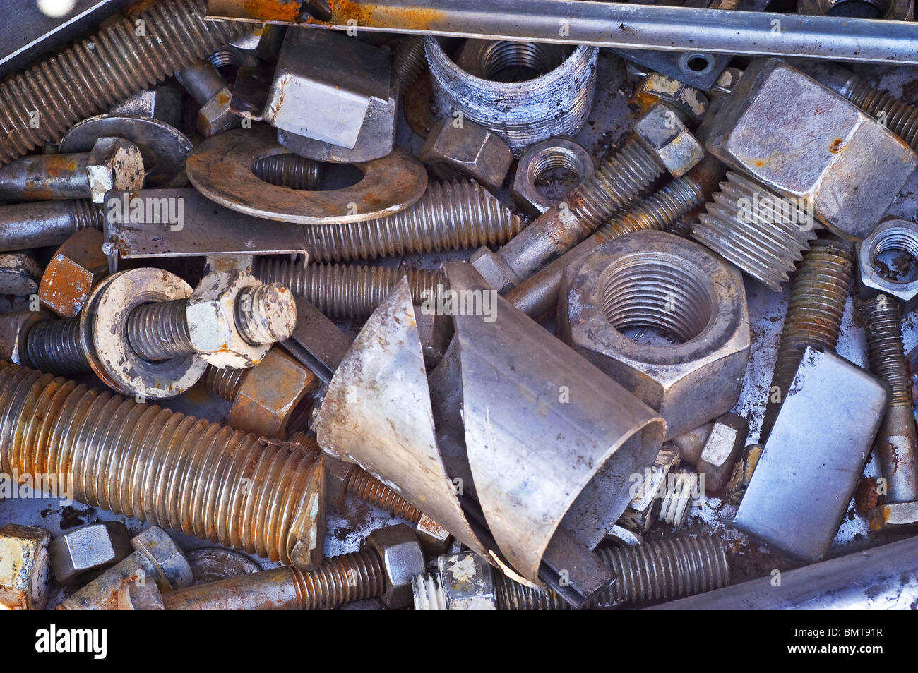 Scrap metal nuts and bolts in a separating bin ready for recycling