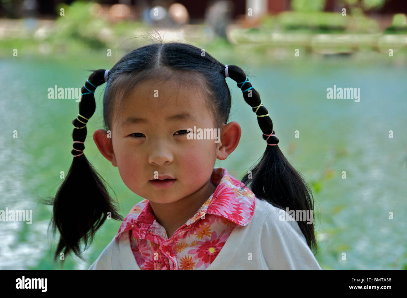 Portrait of five year old girl with pig tails Lijiang Yunnan China Stock Photo