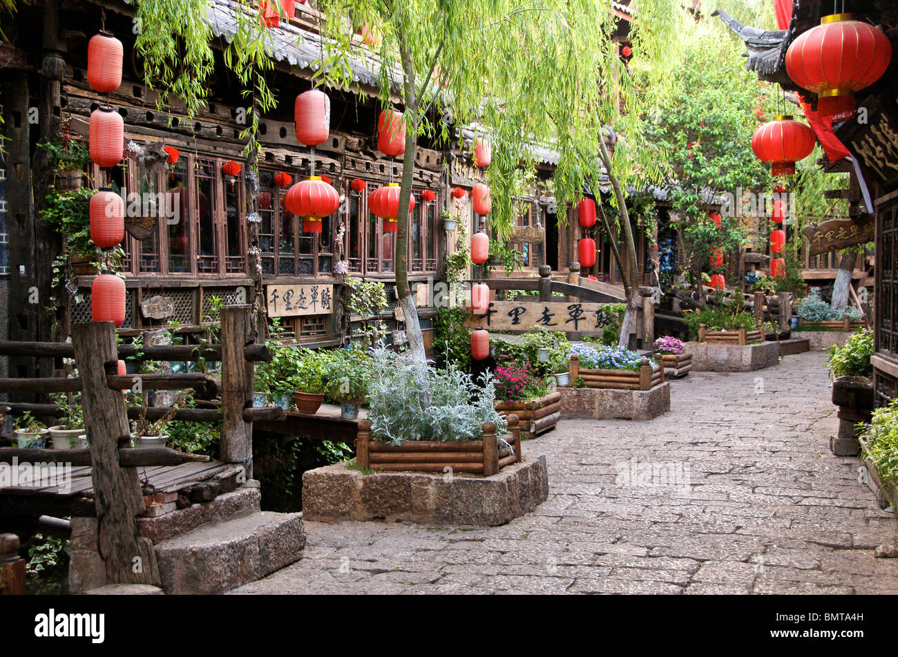 Early morning canal and street with restaurants and hanging chinese lanterns Lijiang Old Town Yunnan China Stock Photo