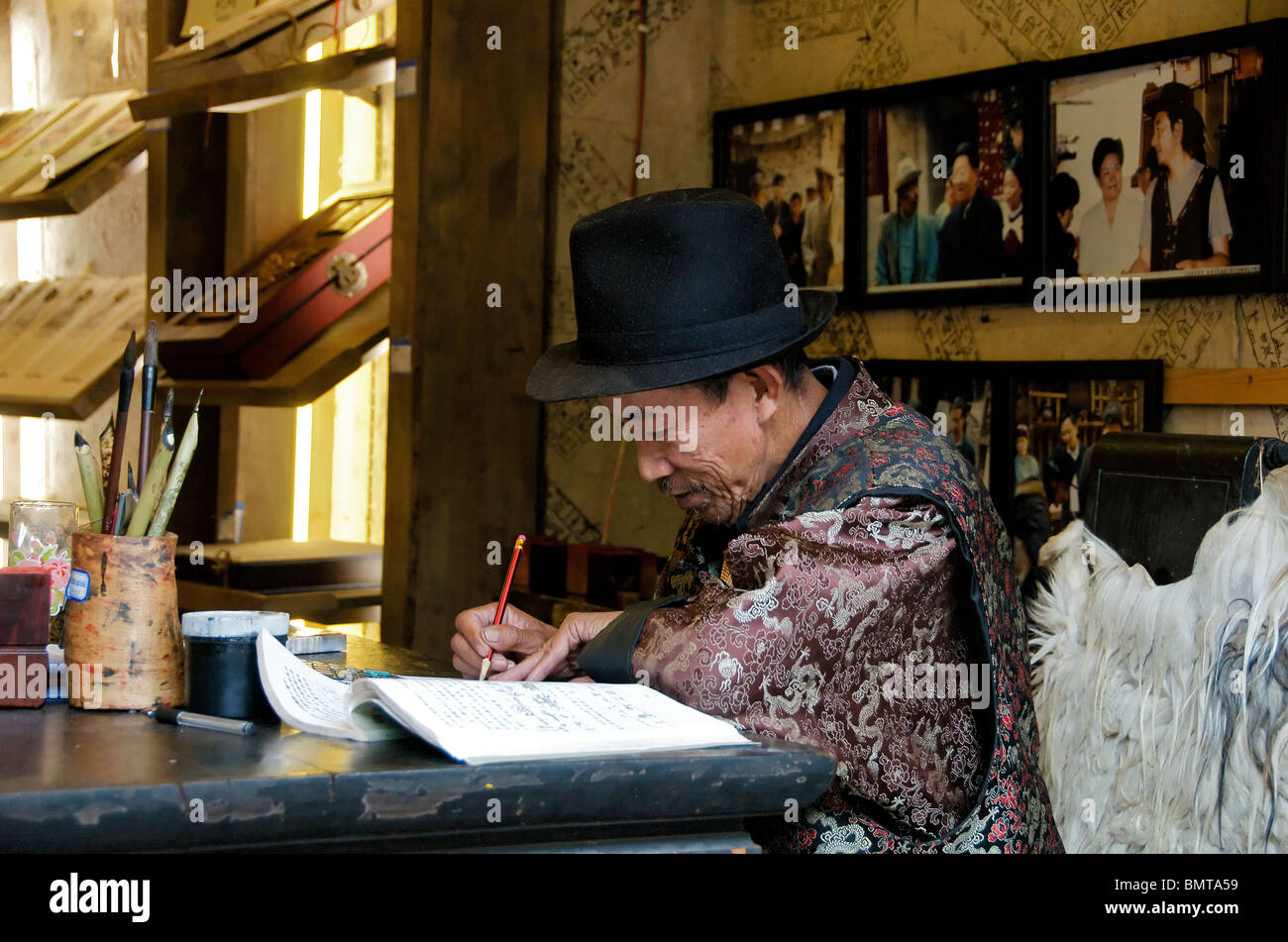 Scribe writing in shop Lijiang Old Town Yunnan China Stock Photo