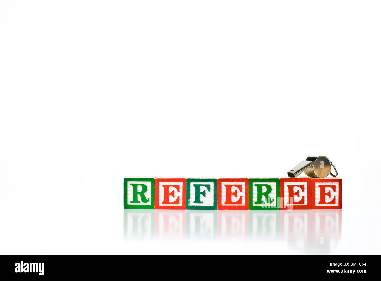 Colorful children's blocks spelling REFEREE with a metal whistle Stock Photo