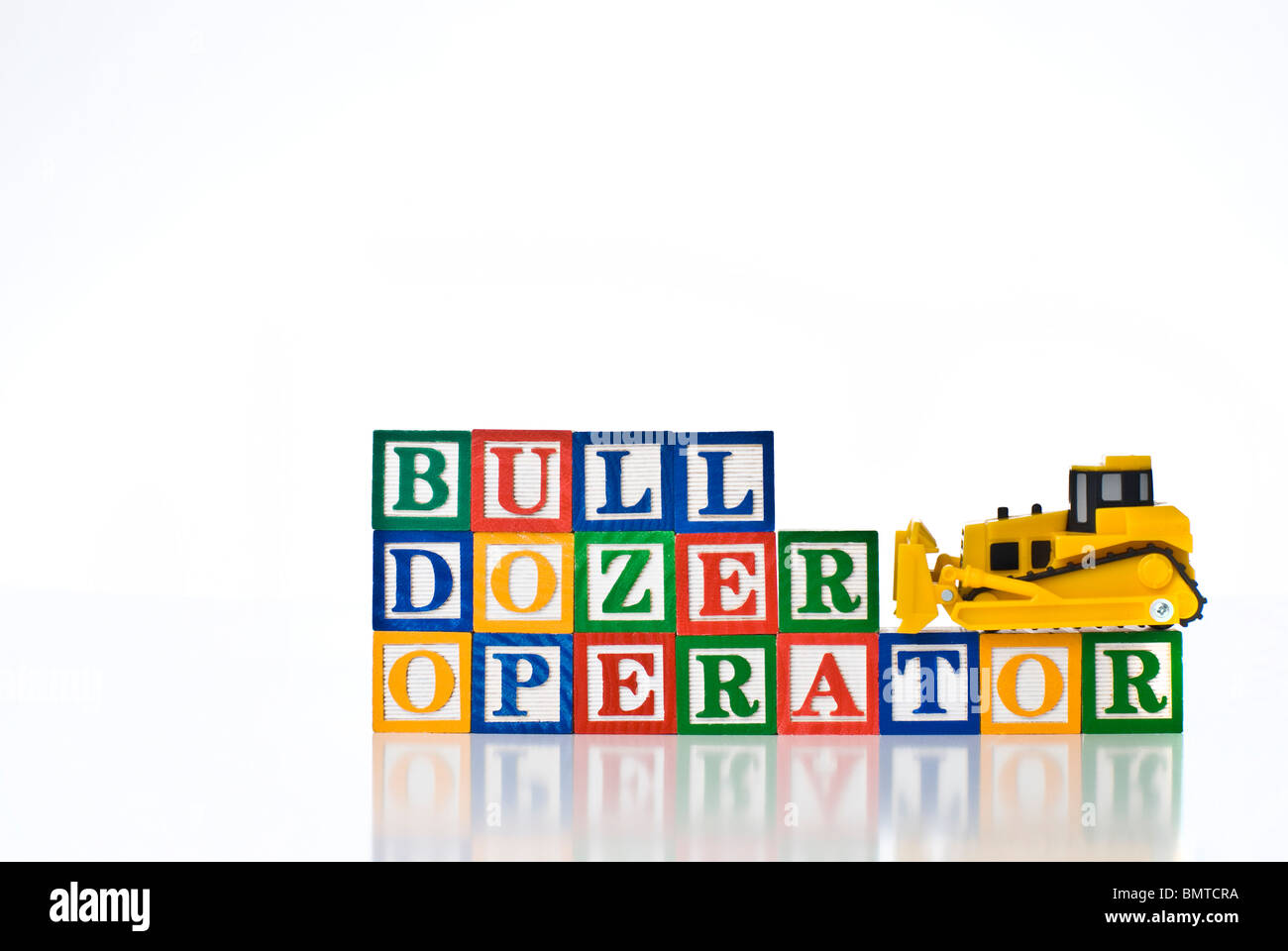 Colorful children's blocks spelling BULL DOZER OPERATOR with a model