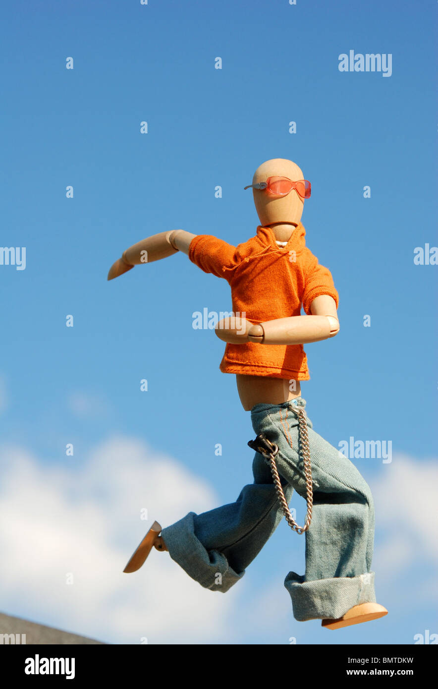 Wooden art model figure running with the sky in the background. Stock Photo