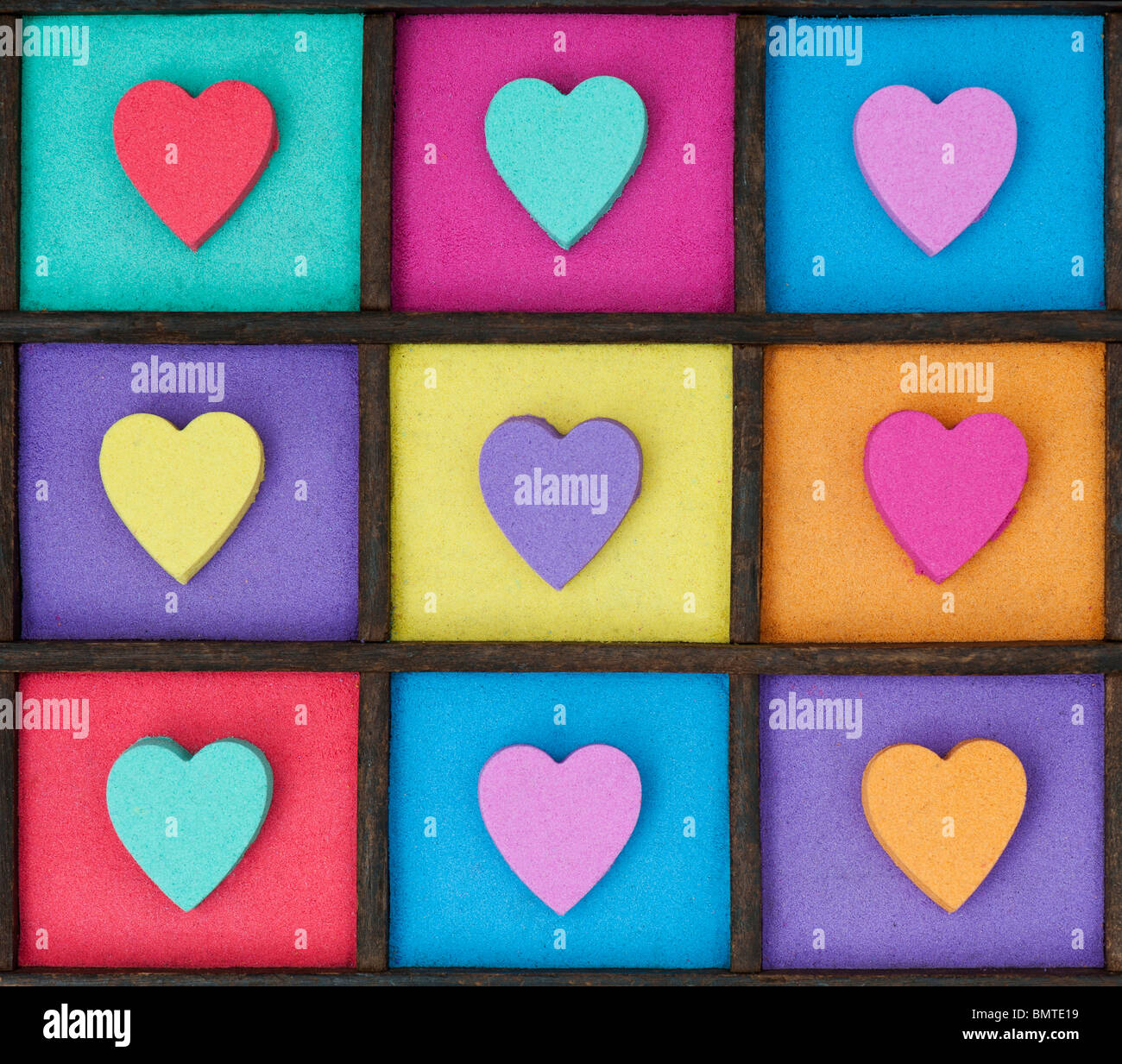 Multicoloured heart shape pattern in a wooden tray Stock Photo