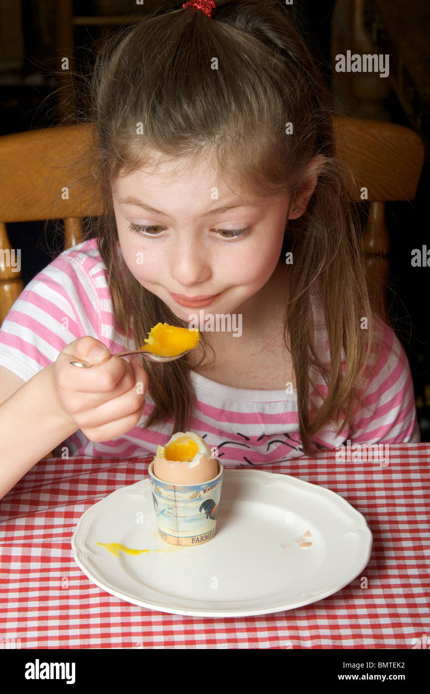 Young girl eating soft boiled egg for breakfast Stock Photo Alamy