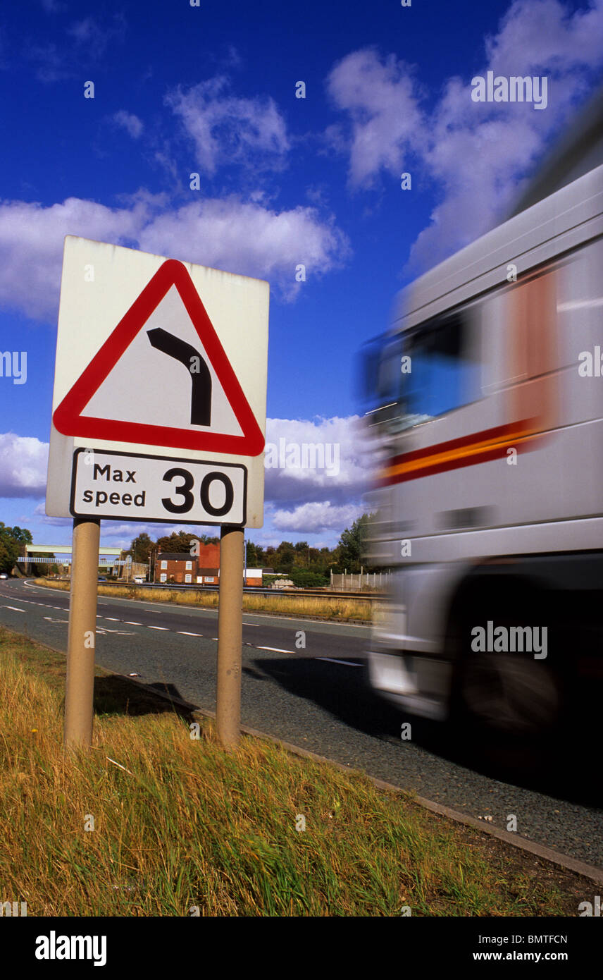 lorry passing warning sign of 30 mph speed limit and sharp left hand bend in the road ahead Ferrybridge yorkshire uk Stock Photo