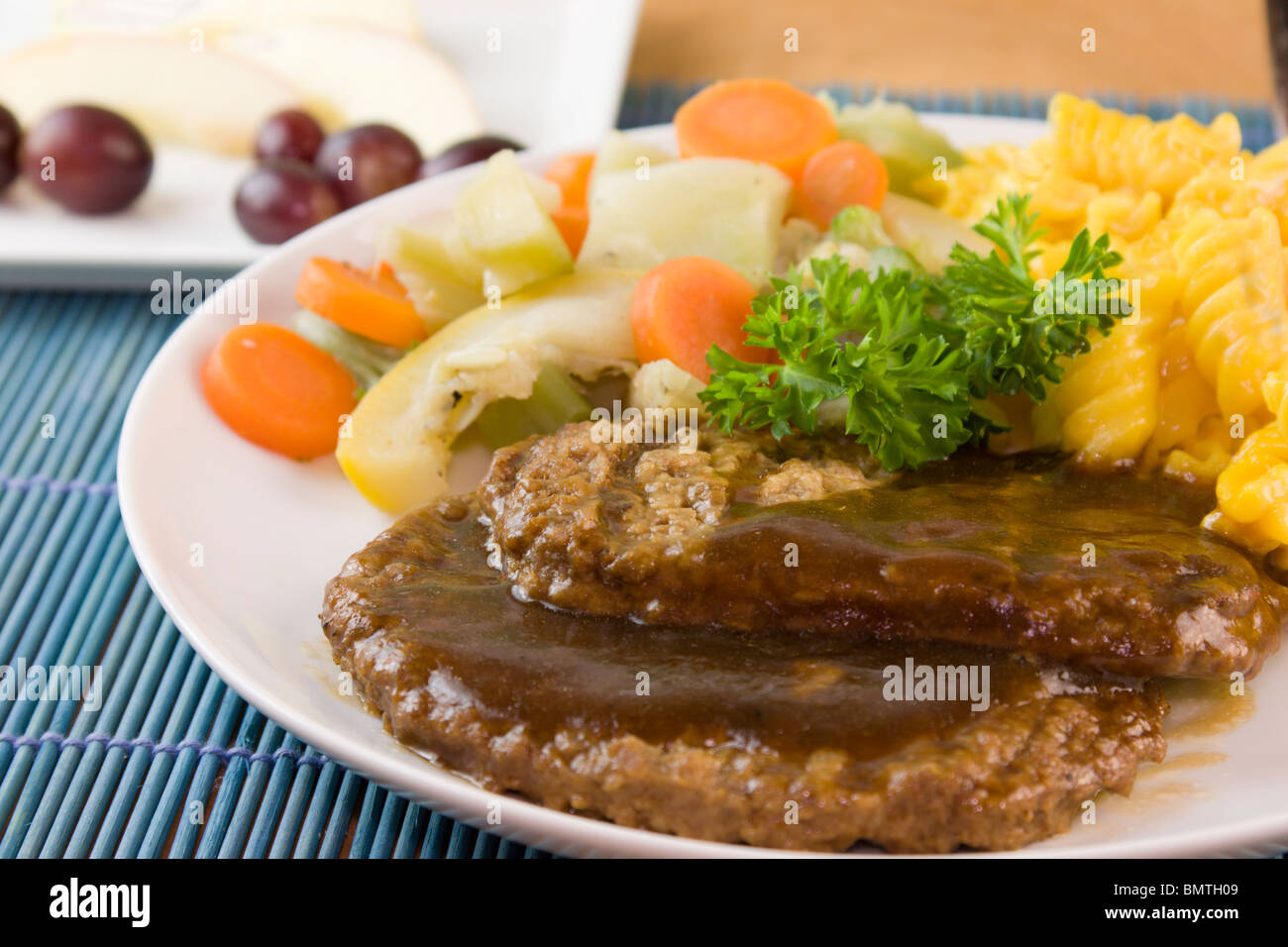 detail of salisbury steak patties with steam vegetables and spiral macaroni Stock Photo