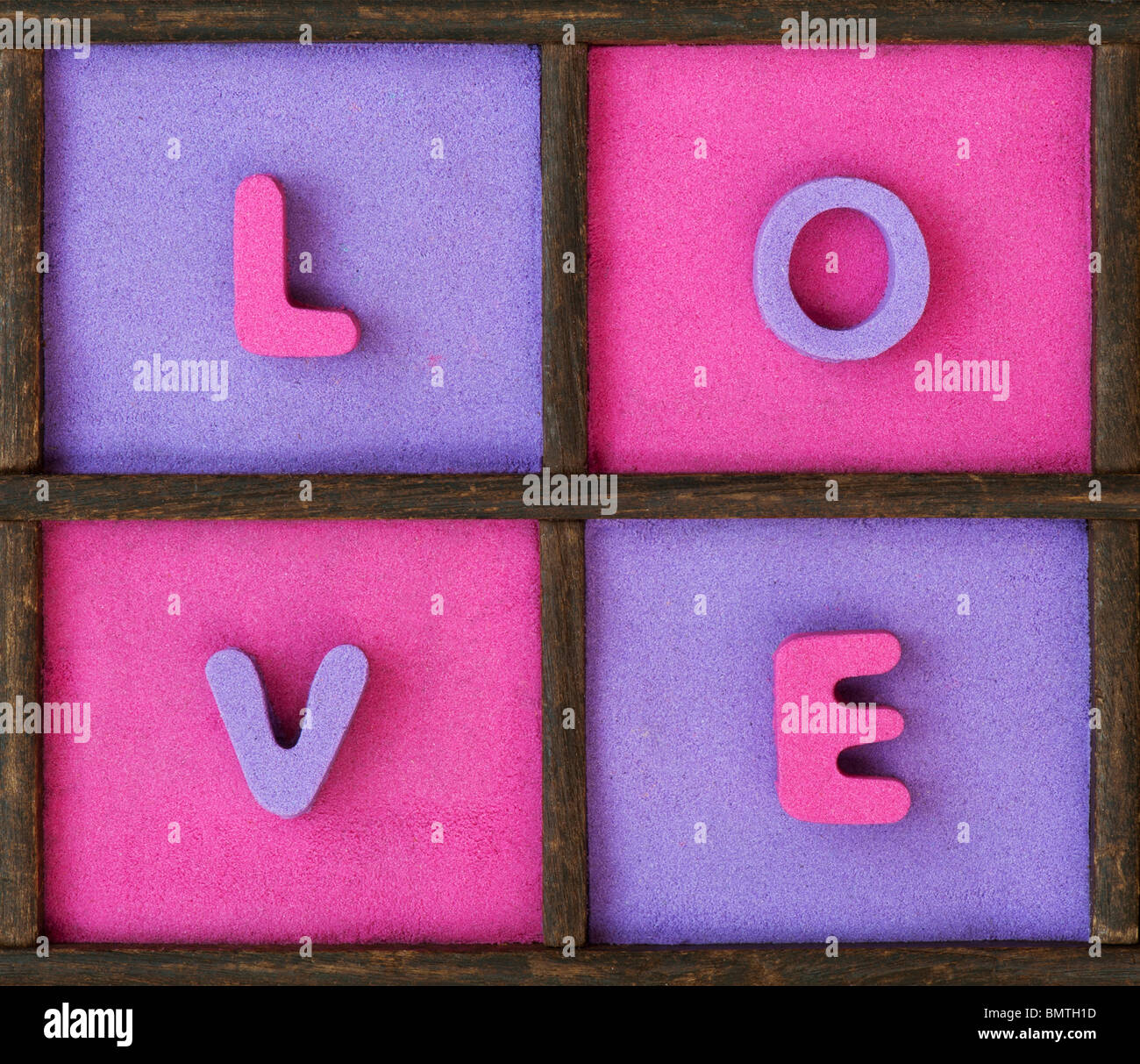 Multicoloured LOVE text in a wooden tray Stock Photo