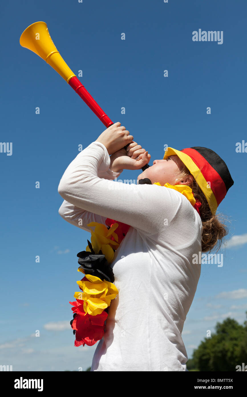 Female soccer fan blows vuvuzela Stock Photo