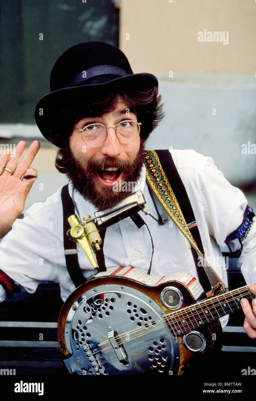 A talented street musician performs enthusiastically with his banjo