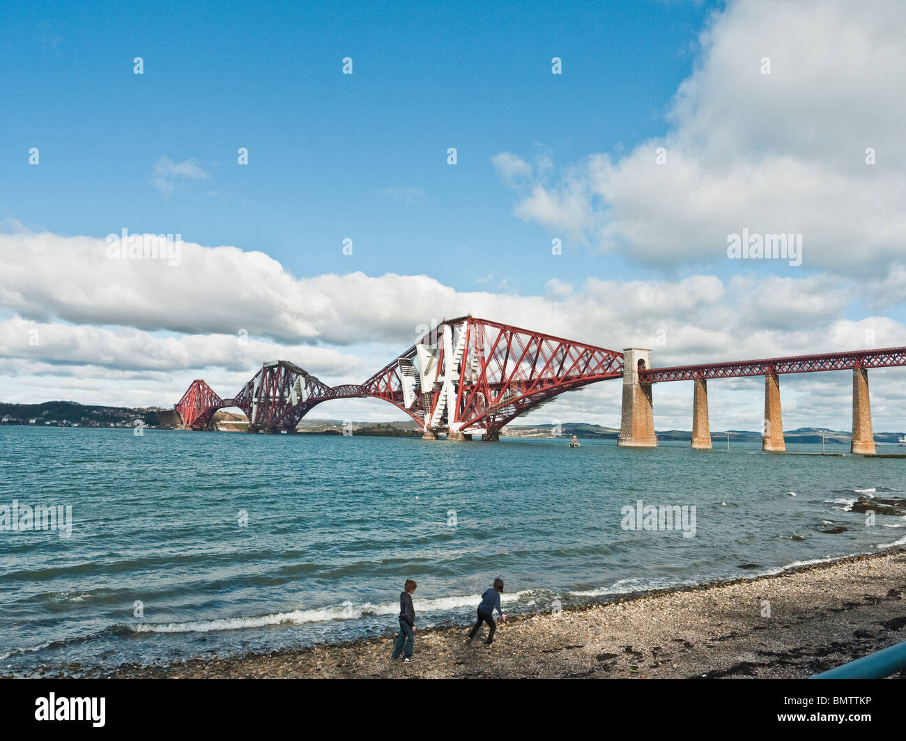 Children skimming stones on the beach near the Forth Rail bridge, South