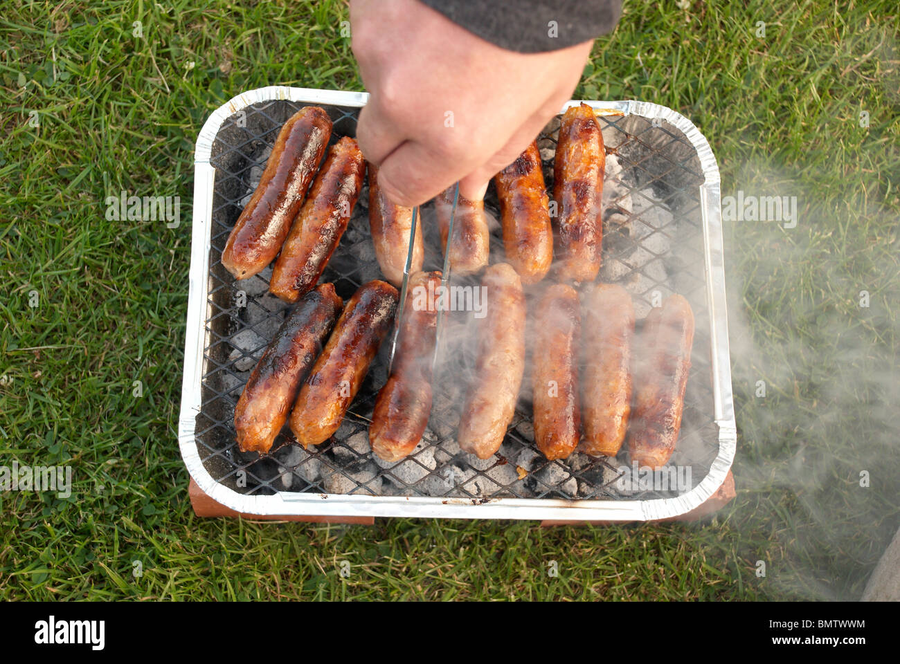Sausages on a disposable bbq Stock Photo Alamy