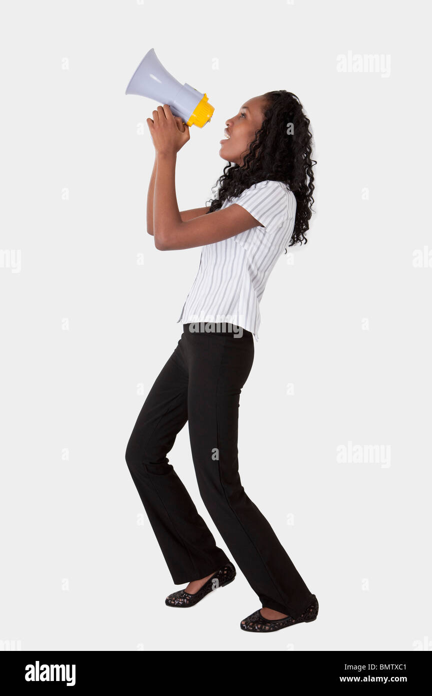 Young woman shouting with a megaphone and looking away Stock Photo