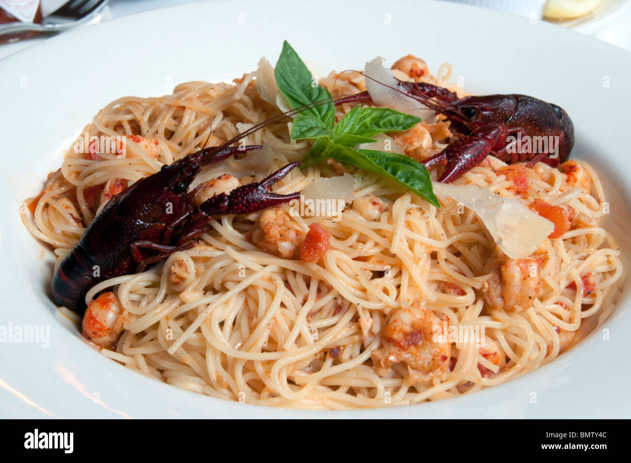 Crawfish Pomodoro pasta - Louisiana crawfish tails, tomatoes, fresh basil and garlic tossed with capellini. A Cajun recipe. Stock Photo